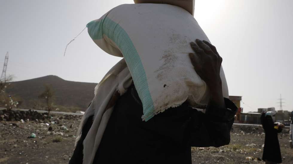 epa10037486 Displaced Yemenis receive food aid amid a heightened food insecurity, at a camp for Internally Displaced Persons (IDPs) on the outskirts of Sana'a, Yemen, 29 April 2022 (issued 27 June 2022). The World Food Programme (WFP) announced on 27 June 2022 that it was forced to reduce aid to millions of people at risk of hunger in war-ravaged Yemen due to a financial shortfall and the knock-on effects of the war in Ukraine. WFP provides monthly food aid to about 13 million out of Yemen's 30-million population. Five million Yemenis are now receiving less than 50 percent of their daily requirement, while another eight million are receiving only 25 percent of their daily needs. Yemen is experiencing a severe food insecurity because of more than seven years of war between the Houthis and the Saudi-backed government.  EPA/YAHYA ARHAB