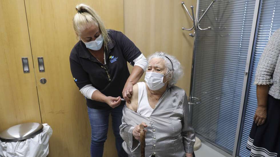 Uma utente é vacinada no arranque da campanha de vacinação sazonal contra a gripe e a covid-19. A campanha de vacinação do outono e inverno prevê a coadministração das vacinas contra a gripe e covid-19 em idosos, pessoas com mais de 18 anos com doenças graves, profissionais de saúde e utentes de lares e cuidados continuados. Pavilhão Desportivo Carlos Queiroz em Carnaxide, 7 de setembro de 2022. MIGUEL A. LOPES / LUSA