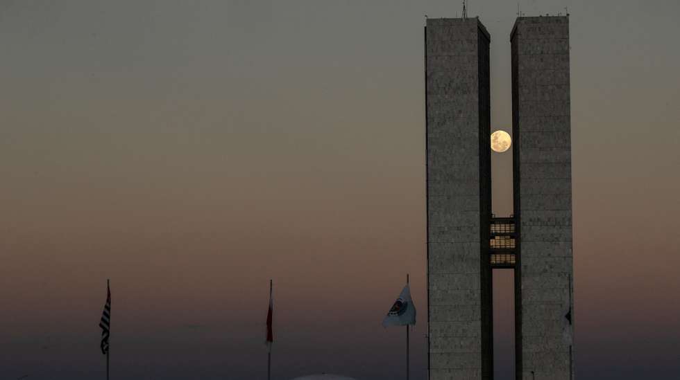 epa09227788 View of the full moon between the two towers of the National Congress building, in Brasilia, Brazil, 25 May 2021.  EPA/Joedson Alves