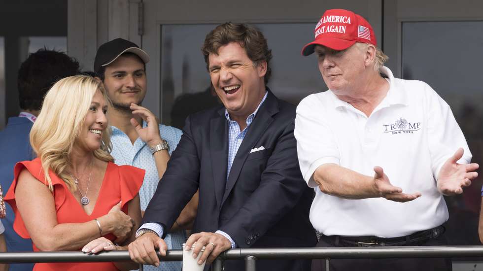 epaselect epa10100951 (L-R) Republican Congresswoman Majorie Taylor Greene of Georgia, Fox News television personality Tucker Carlson, and former US President Donald J. Trump watch the third round of the LIV Golf Bedminster invitational, part of the new LIV Golf Invitational Series, at the Trump National Golf Club in Bedminster, New Jersey, USA, 31 July 2022.  EPA/JUSTIN LANE