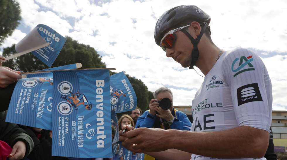 epa10514944 Portuguese rider Joao Almeida of the team UAE Team Emirates signs autographs before the 6th stage of the Tirreno Adriatico cycling race, over 193km from Osimo Stazione to Osimo, Italy, 11 March 2023.  EPA/ROBERTO BETTINI