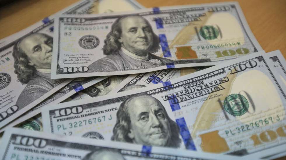 epa10210339 US dollar banknotes are displayed on a table at a money exchange company in Nairobi, Kenya, 27 September 2022. A worker points at the Euro currency exchange rate against the Kenyan shilling on a currency board at a money exchange company in Nairobi, Kenya, 27 September 2022.  EPA/Daniel Irungu