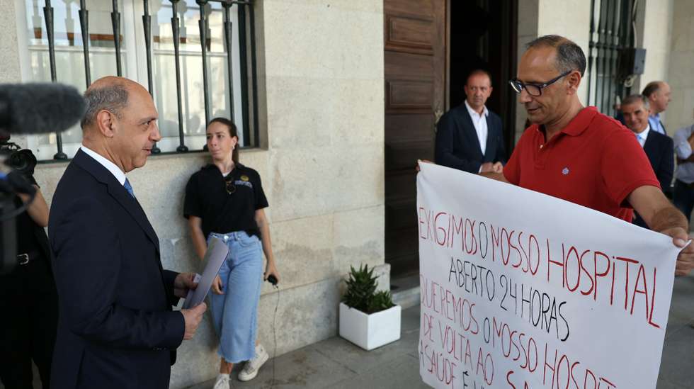 Elementos do Movimento de Defesa do Hospital de São Paulo (HSP) protestam à chegada do ministro da Saúde, Manuel Pizarro (E), à chegada para uma visita ao Centro de Saúde de Serpa, no âmbito da 4.ª edição da iniciativa Saúde Aberta, em Serpa, 03 de julho de 2023. A iniciativa Saúde Aberta, do Ministério da Saúde, regressa à estrada no distrito de Beja para conhecer as unidades e investimentos em curso e dialogar com a população, profissionais de saúde, órgãos dirigentes do Serviço Nacional de Saúde (SNS) e autarcas. NUNO VEIGA/LUSA