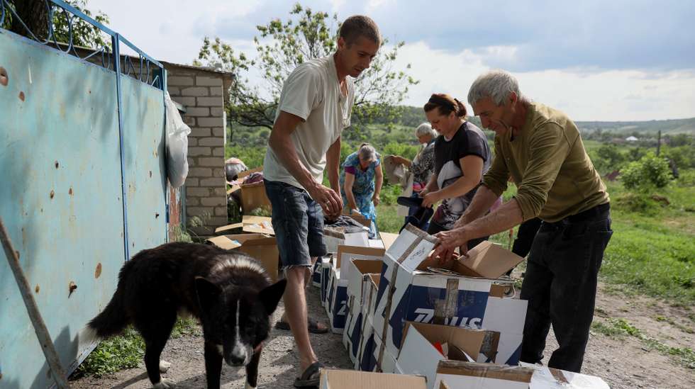 epa10656961 Local residents share humanitarian aid in Bohorodychne village, Donetsk region, 26 May 2023 (issued 27 May 2023). Bohorodyche had a population of roughly 600 persons before the war. Only 18 individuals have returned to their houses as of yet. Russian troops entered Ukraine on 24 February 2022 starting a conflict that has provoked destruction and a humanitarian crisis.  EPA/OLEG PETRASYUK  ATTENTION: This Image is part of a PHOTO SET