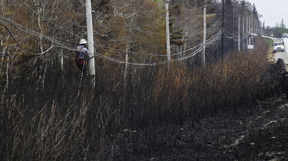 epa10681523 A handout photo made available Communications Nova Scotia showing utility workers replacing fiber optic lines following damage from the Barrington Lake Wildfire in Barrington, Nova Scotia, Canada, 08 June 2023 (issued on 09 June 2023. Smoke from the ongoing Canadian wildfires continues to impact air quality conditions across multiple US cities.  EPA/COMMUNICATIONS NOVA SCOTIA HANDOUT 
NO ALTERATIONS OTHER THAN CROPPING HANDOUT EDITORIAL USE ONLY/NO SALES