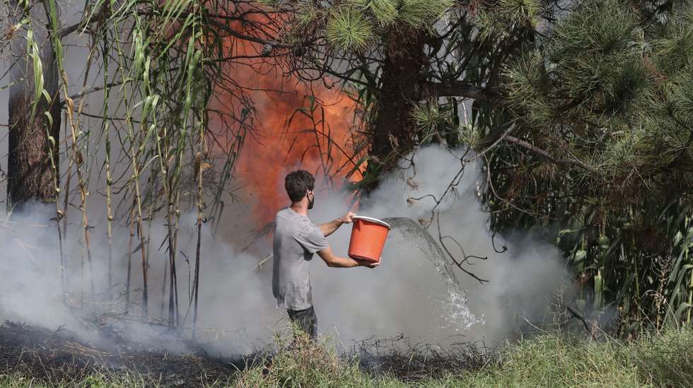 Populares tentam apagar o incêndio no concelho da Calheta, Madeira, 12 de outubro de 2023. O incêndio deflagrou cerca das 18:00 de quarta-feira na freguesia dos Prazeres, no município da Calheta, na zona oeste da Madeira, e motivou a retirada de 120 hóspedes do Hotel Jardim Atlântico”, cerca das 20:00, embora o fogo não tenha atingido a infraestrutura. HOMEM DE GOUVEIA/LUSA