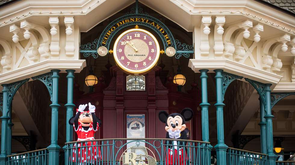 epa08547270 Performers wearing Mickey and Minnie Mouse costumes greet the first visitors of the Disneyland Paris theme park the day of the official reopening  in Marne-la-Vallee, near Paris, France, 15 July 2020. Disneyland Paris closed on 15 March 2020 due to the coronavirus disease (COVID-19) outbreak.  EPA/CHRISTOPHE PETIT TESSON