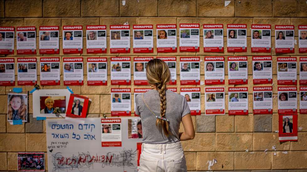 epa10925499 A woman looks at pictures of the hostages held by Hamas militants in Gaza, outside of the Israeli military base of The Kirya in Tel Aviv, Israel, 18 October 2023. More than 3,000 Palestinians and 1,400 Israelis have been killed according to the Israel Defense Forces (IDF) and the Palestinian Health authority since Hamas militants launched an attack against Israel from the Gaza Strip on 07 October.  EPA/MARTIN DIVISEK