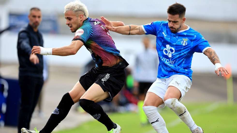 O jogador do Canelas 2010, Gonçalo Lixa (D), disputa a bola com o jogador do Desportivo de Chaves, Benny Sousa, durante o jogo da 3.ª eliminatória da Taça de Portugal de futebol, realizado no Estádio Clube Futebol Canelas 2010, em Vila Nova de Gaia, 22 de outubro 2023. ESTELA SILVA/LUSA