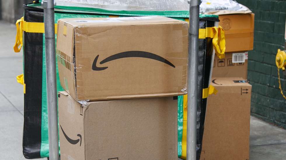 epa10941441 Amazon boxes sit on a cart while a worker makes a delivery in New York, New York, USA, 26 October 2023. Amazon.com is expected to post its quarterly earnings on 26 October. The company last posted its quarterly earnings results on 03 August 2023.  EPA/SARAH YENESEL
