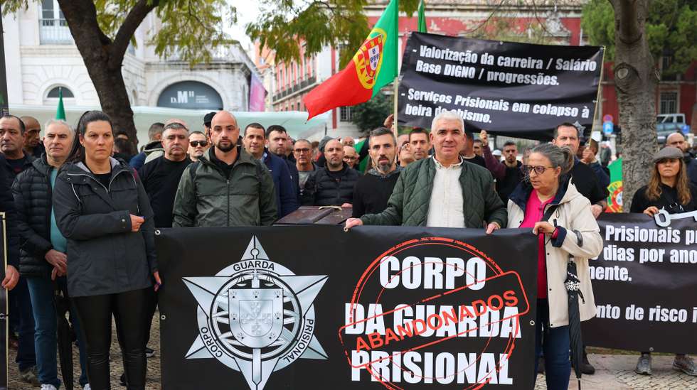 Guardas prisionais participam uma "marcha fúnebre", carregando um caixão, até ao Ministério da Justiça, para exigir melhores condições e uma equiparação ao suplemento de missão atribuído à PJ, em Lisboa, 22 de fevereiro de 2024. ANTÓNIO COTRIM/LUSA