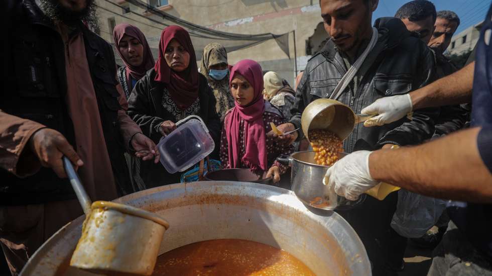 epa11178802 Internally displaced Palestinians receive food provided by Arab and Palestinian donors in Deir Al Balah town, southern Gaza Strip, 24 February 2024. Since 07 October, up to 1.9 million people, or more than 85 percent of the population, have been displaced throughout the Gaza Strip, some more than once, according to the United Nations Relief and Works Agency for Palestine Refugees in the Near East (UNRWA), which added that most civilians in Gaza are in 'desperate need of humanitarian assistance'.  EPA/MOHAMMED SABER