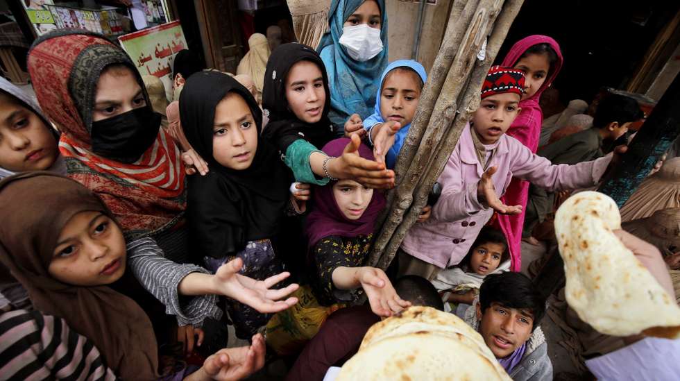 epa11229570 A man distributes free food to children to break their fast, during the fasting month of Ramadan in Peshawar, Pakistan, 19 March 2024. The Muslims' holy month of Ramadan is the ninth month in the Islamic calendar and it is believed that the revelation of the first verse in the Koran was during its last 10 nights. It is celebrated yearly by praying during the night time and abstaining from eating, drinking, and sexual acts during the period between sunrise and sunset. It is also a time for socializing, mainly in the evening after breaking the fast and a shift of all activities to late in the day in most countries.  EPA/BILAWAL ARBAB