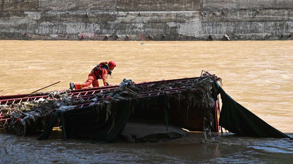 epa11490493 A rescuer works at the lower reaches of the river near a bridge collapse site in Zhashui County in Shangluo City, Shaanxi Province, China, 21 July 2024. Over 1,500 locals joined more than 700 rescuers searching for 31 people who were unaccounted for after their vehicles plunged into a flooding river due to a highway bridge collapse amid torrential rains on 20 July, when at least 12 people had been confirmed dead, according to local authorities.  EPA/XINHUA / Zou Jingyi CHINA OUT / UK AND IRELAND OUT  /       MANDATORY CREDIT EDITORIAL USE ONLY