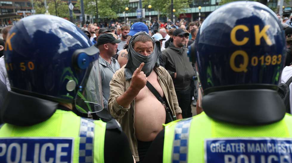 epa11522439 Protesters confront police in Manchester, Britain, 03 August 2024. Violent demonstrations by members of far-right groups have sprung up across Britain in the aftermath of a fatal stabbing attack in Southport, in which three children were killed and eight more seriously injured along with two adults.  EPA/STR