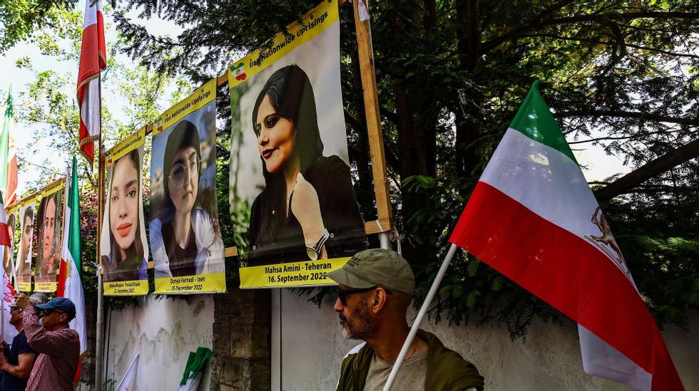 epa11355190 A protester holds an Iranian national flag next to a picture of the late Mahsa Amini during a protest of the National Council of Resistance of Iran (NWRI) against the Iranian regime in front of the Embassy of the Islamic Republic of Iran, in Berlin, Germany, 20 May 2024. Iran&#039;s President Ebrahim Raisi, Foreign Minister Hossein Amir-Abdollahian and several others were killed in a helicopter crash on 19 May 2024, after an official visit in Iran&#039;s northwest near the border with Azerbaijan, the Iranian government confirmed.  EPA/FILIP SINGER