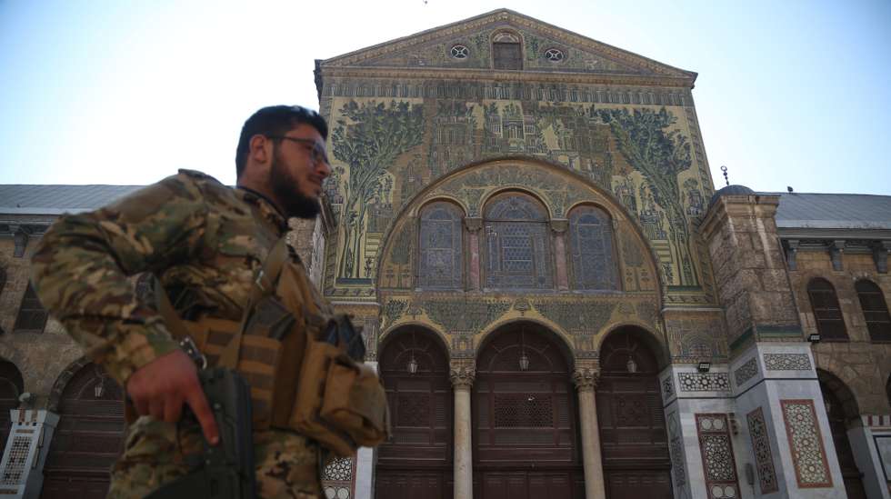 epaselect epa11766260 An armed rebel walks in the Umayyad Mosque in Damascus, Syria, 09 December 2024. Syrian rebels entered Damascus on 08 December 2024 and announced in a televised statement the 'Liberation of the city of Damascus and the overthrow of Bashar al-Assad', as well as the release of all the prisoners.  EPA/BILAL ALHAMMOUD