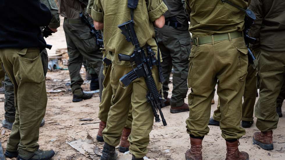 epa10989464 Israeli soldiers stand guard near the security fence along the border with the Gaza Strip during a press visit at Kfar Aza Kibbutz, southern Israel, 22 November 2023. The kibbutz, located near the Gaza border, was the scene of an Hamas attack on 07 October which resulted in the deaths of dozens of Israelis. More than 12,700 Palestinians and at least 1,200 Israelis have been killed, according to the Israel Defense Forces (IDF) and the Palestinian health authority, since Hamas militants launched an attack against Israel from the Gaza Strip on 07 October, and the Israeli operations in Gaza and the West Bank which followed it.  EPA/CHRISTOPHE PETIT TESSON