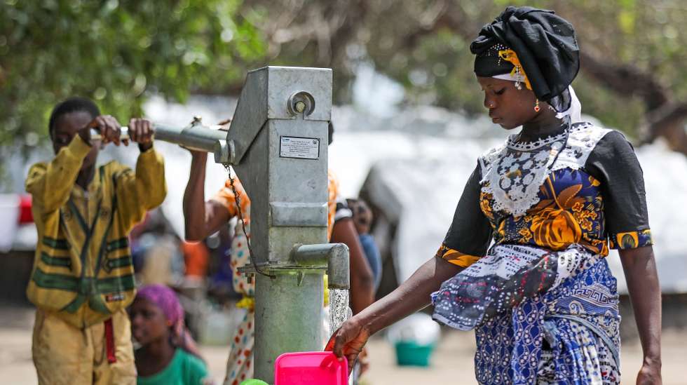 epa09127274 A mother and her son take water from a fountain in 25 June Camp for Internally Displaced People (IDP) in Belibize, near Metuge, northern Mozambique, 10 April 2021. The violence unleashed more than three years ago in Cabo Delgado province escalated again about two weeks ago, when armed groups first attacked the town of Palma, forcing people to flee from a conflict zone.  EPA/JOAO RELVAS