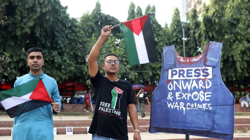 epa11722596 Bangladeshi people hold Palestinian flags during a protest and exhibition against the killing of Palestinian journalists, in Dhaka, Bangladesh, 15 November 2024. The Drik Picture Library organized at Dhanmondi's Rabindra Sarobar, in Dhaka, an exhibition titled 'Gaza Holocaust: Killing the Truthtellers' to protest against the killing of Palestinian journalists during the ongoing Israeli-Hamas conflict. According to Reporters Without Borders, over 130 journalists have been killed by Israeli forces in Gaza since 07 October 2023.  EPA/MONIRUL ALAM