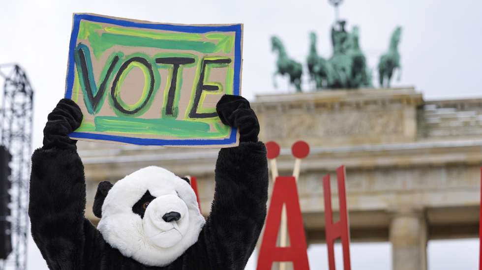 epa11895398 A protester dressed as a panda bear holds a cardboard that reads 'VOTE' during a Fridays for Future climate strike protest in Berlin, Germany, 14 February 2025. Fridays for Future is calling for a nationwide climate strike on 14 February, around a week before the federal elections, with actions planned in over 120 locations throughout Germany. The activists want to send a signal against the shift to the right in favor of democracy and climate protection, as they demand, among other things, a fund for climate adaptation and disaster relief, and climate neutrality by 2035.  EPA/CHRISTOPHER NEUNDORF