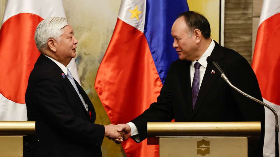 epa11920434 Philippine Defense Secretary Gilberto Teodoro Jr.(R), and Japan Defense Minister Gen Nakatani (L) shake hands during a press conference following a ministerial meeting in Makati City, Metro Manila, Philippines, 24 February 2025. The Philippines and Japan are in discussion to improve defense partnership and regional security initiatives.  EPA/ROLEX DELA PENA