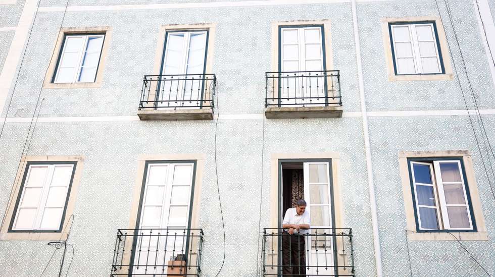 Um morador observa o movimento da rua da janela de sua casa, em Lisboa, 19 de agosto de 2024. Habitação. Rendas. Imobiliário. ANTÓNIO PEDRO SANTOS/LUSA
