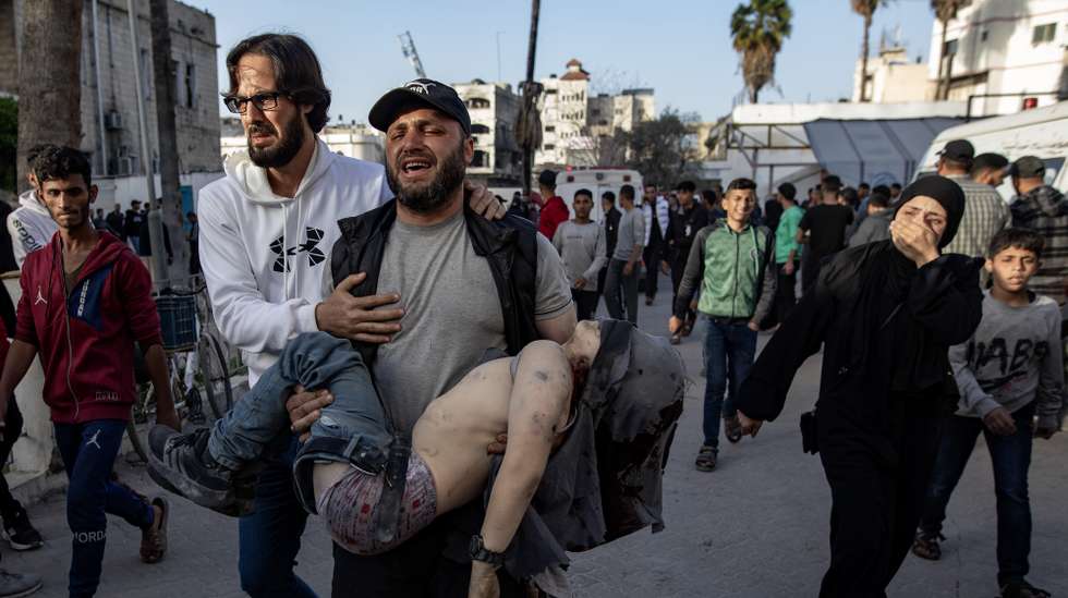 epa12007934 A man carries the body of his son who was killed in an Israeli airstrike, at the Al-Ahli Hospital in Gaza, 03 April 2025. At least 27 people were killed in an Israeli airstrike on the Dar al-Arqam School in the al-Tuffah neighborhood, east of Gaza City, according to the Palestinian Ministry of Health in Gaza. Israeli forces resumed airstrikes on Gaza on 18 March, ending a ceasefire that had been in place since 19 January.  EPA/HAITHAM IMAD