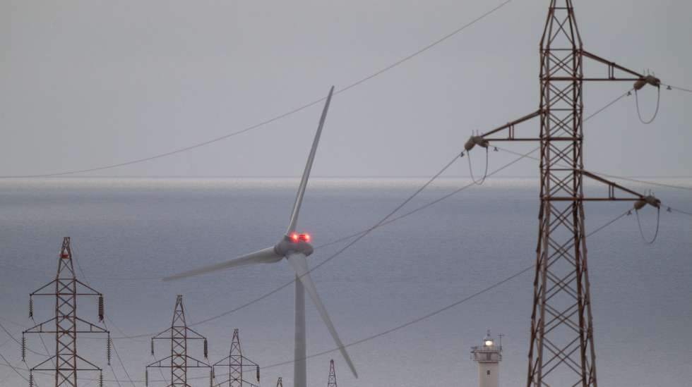 epa12062143 High voltage power lines and a wind turbine on Fuerteventura Island, Canary Islands, southwestern Spain, 29 April 2025. The massive power outage that affected the Iberian peninsula a day earlier did not affect the Canary Islands. A power blackout hit large parts of Spain and spread to neighboring Portugal and France on 28 April, disrupting transport systems, internet connections, and daily life, according to authorities. The exact cause of the outage is unknown.  EPA/CARLOS DE SAA