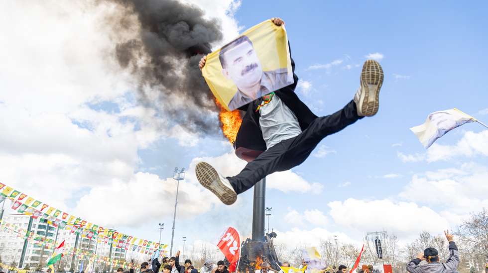 epa11978449 Supporters of The Peoples' Equality and Democracy Party (DEM) hold pictures of Kurdistan Workers' Party (PKK) jailed leader Abdullah Ocalan, and shout slogans next to a bonfire during a rally for Newruz celebrations in Diyarbakir, Turkey, 21 March 2025. Newroz or Nowruz, which means 'new day' in the Persian language, marks the arrival of spring and the first day in the Iranian calendar. It is widely celebrated in the Persian and neighboring regions and recognized on the UNESCO List of the Intangible Cultural Heritage of Humanity.  EPA/METIN YOKSU
