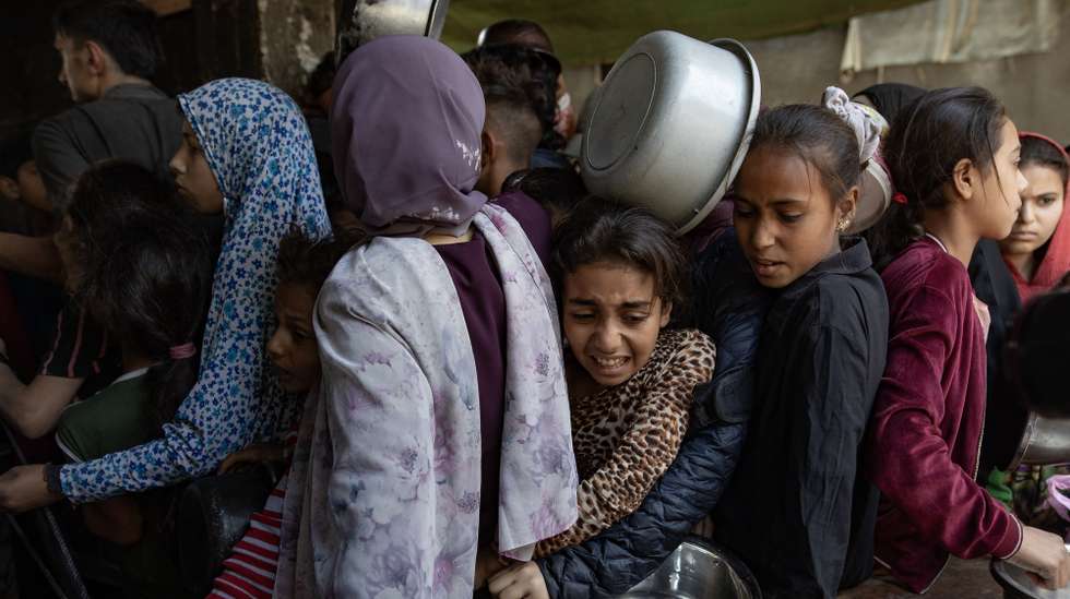 epa12122619 Hundreds of displaced Palestinians gather outside the Sokar Charity Kitchen in Gaza City to receive limited food rations,21 May, 2025. Kitchen officials say their stocks ran out today due to the suspension of humanitarian aid entering the Gaza Strip.  EPA/HAITHAM IMAD
