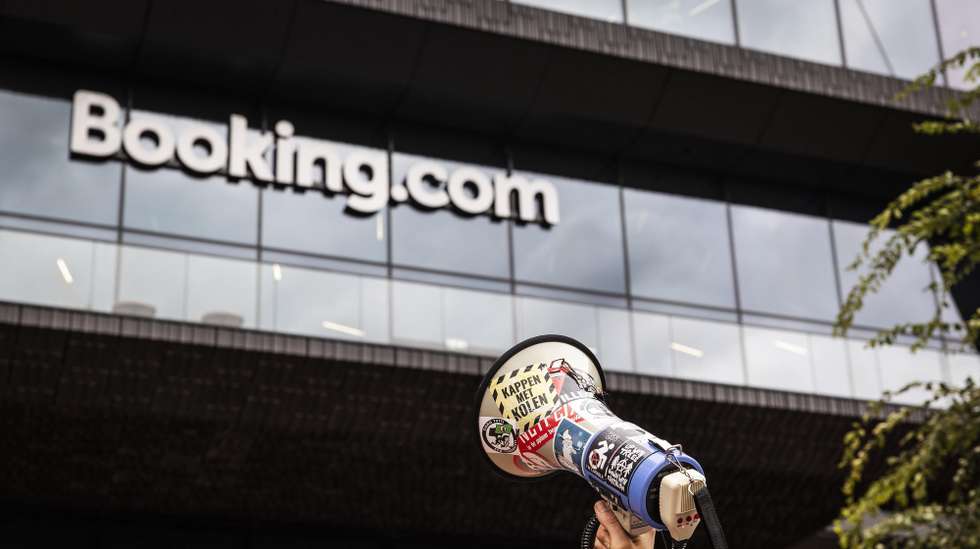 epa11649515 A protester holds a megaphone in front of the travel accommodation reservation site Booking.com headquarters during a pro-Palestinian protest, in Amsterdam, Netherlands, 08 October 2024.Pro-Palestinian activists are demanding that Booking.com stop reservations in the West Bank.  EPA/DINGENA MOL
