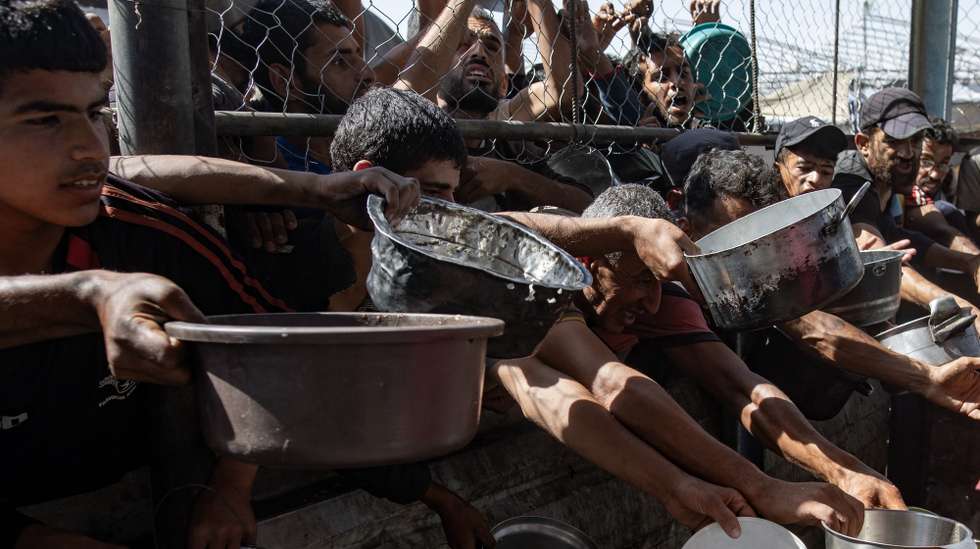 epa12144624 Internally displaced Palestinians gather outside a charity kitchen to receive limited rations amid a shortage of food, in Khan Younis, southern Gaza Strip, 30 May 2025. The United Nations has warned that "the entire population of Gaza is facing the risk of famine" since Israel closed border crossings on 02 March 2025, preventing the entry of essential supplies. The Gaza Government Media Office reported on 24 May that at least 58 people died due to malnutrition, and nearly 250 others due to a lack of food and medicine.  EPA/HAITHAM IMAD