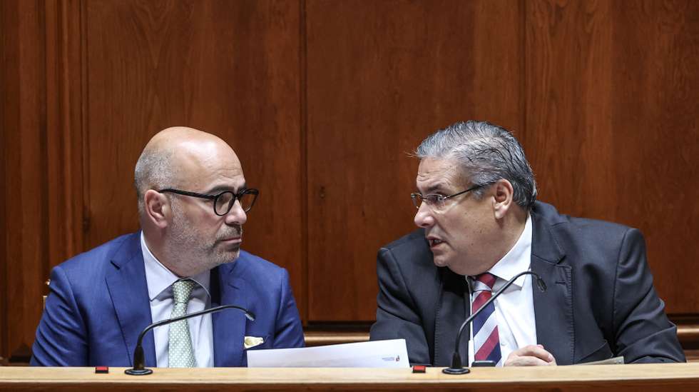 O ministro dos Assuntos Parlamentares, Carlos Abreu Amorim (D), conversa com o ministro das Infraestruturas e Habitação, Miguel Pinto Luz, durante o debate de urgência, requerido pelo Chega, sobre "Privatização da TAP", Assembleia da República, em Lisboa, 11 de julho  de 2025. ANTÓNIO COTRIM/LUSA