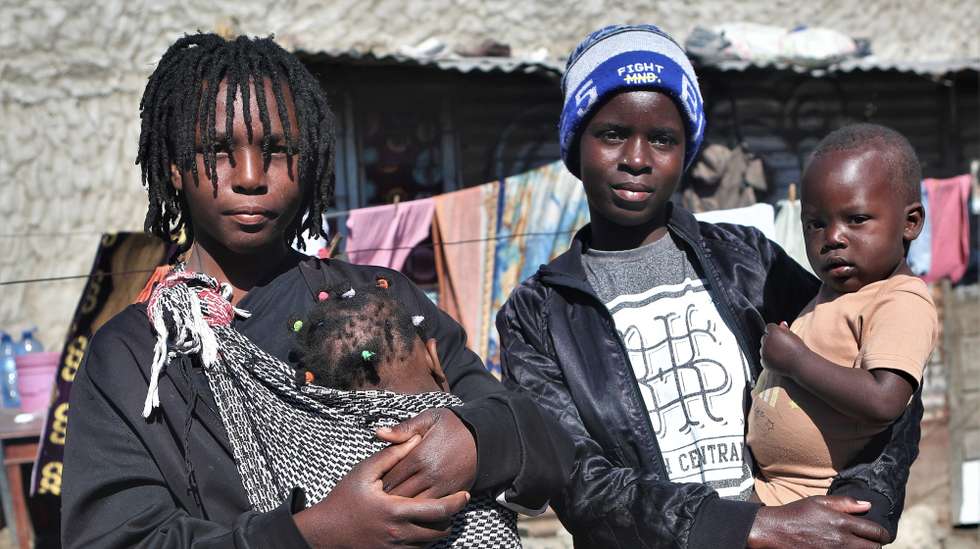 Cíntia Tembe (E), 16 anos, e Hortênsia Zefanias (D), 21 anos, com os seus filhos ao colo, cuja gravidez não foi planeada e ocorreu antes dos 18 anos, no bairro Mafalala, Maputo, Moçambique, 10 de julho de 2025. A vida de raparigas do histórico bairro da Mafalala, em Maputo, é reflexo de um relatório global das Nações Unidas que aponta Moçambique como o país com a quarta maior taxa de natalidade na adolescência, em raparigas de 15 a 19 anos, em todo o mundo, antevendo ainda a duplicação da população em 25 anos. (ACOMPANHA TEXTO DA LUSA DE 14-07-2025) LUÍSA NHANTUMBO/LUSA