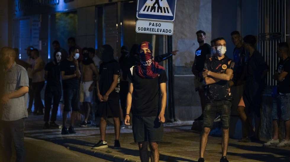 epa12238851 Masked people gather at San Antonio district in the town of Torre Pacheco, Murcia, southeastern Spain, late 14 July 2025. Anti-migrant unrest in Torre Pacheco, which left several people injured and resulted in multiple arrests, was sparked by an assault on a 68-year-old resident, allegedly by migrants, according to authorities. The incident led to three days of violence in the town, which has a population of approximately 40,000 and a large Maghrebi immigrant community.  EPA/PABLO MIRANZO