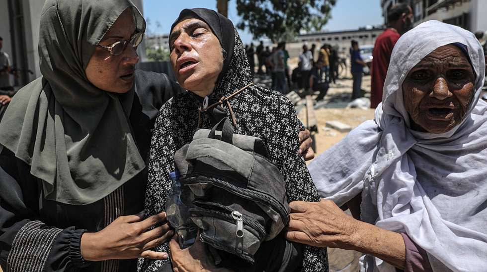 epa12250219 A Palestinian mother (C) hugs the bag of her son while mourning after he was shot dead at a food distribution point, at Al-Shifa Hospital in Gaza City, 20 July 2025. According to the Palestinian Ministry of Health in Gaza, at least 67 people were killed while trying to receive humanitarian aid in the Zikim area.  EPA/MOHAMMED SABER