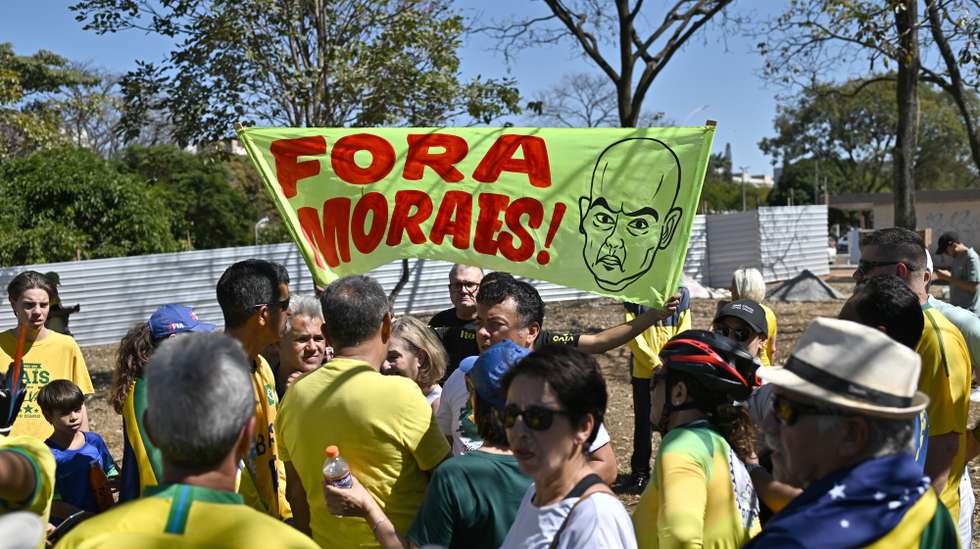 epa12249903 A man holds a sign reading 'Out with Moraes', referring to Brazilian Supreme Court Justice Alexandre de Moraes, during a protest in support of former Brazilian President Jair Bolsonaro in front of the Central Bank in Brasilia, Brazil, 20 July 2025.  EPA/ANDRE BORGES