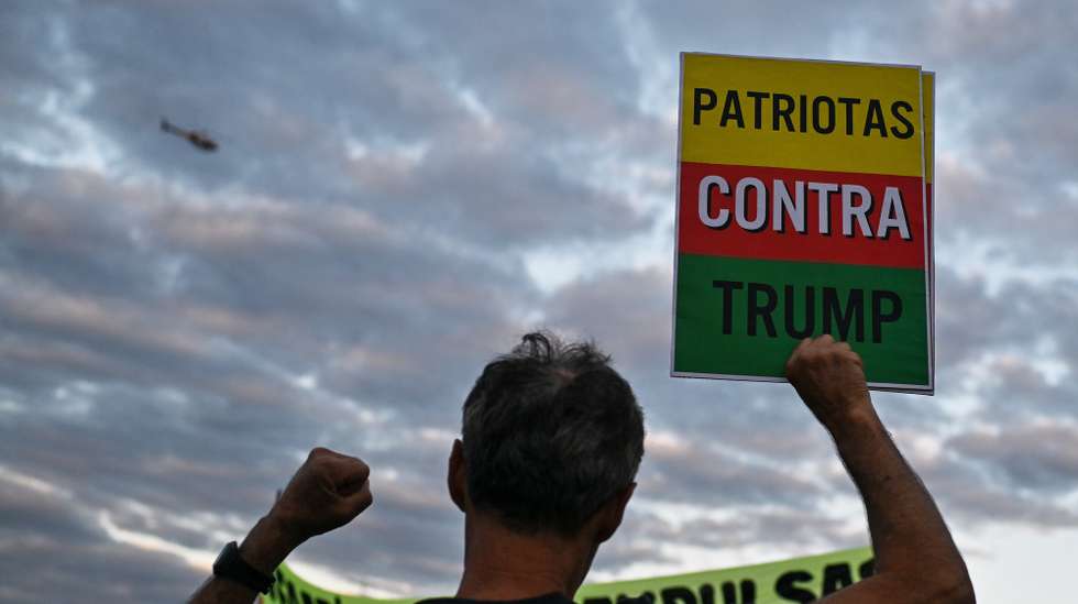 epa12230517 People participate in a protest against Donald Trump's US tariffs, at the central bus station in Brasilia, Brazil, 10 July 2025. Brazilian President Luiz Inacio Lula da Silva announced that he will try to negotiate with the United States to reverse the 50% tariff announced by his counterpart Donald Trump, and that if he fails, he will apply the same measure to US imports.  EPA/Andre Borges
