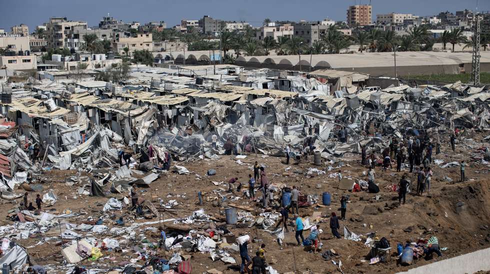 epa12314038 Displaced Palestinians inspect tents destroyed after an Israeli strike on the Al-Manasrah camp, which housed more than 200 families in Deir al-Balah, central Gaza Strip, 21 August, 2025.  EPA/HAITHAM IMAD