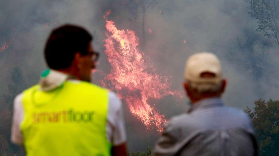 epa12308109 Locals look at a forest fire that started five days ago near the Aldeia de Piodao, in Arganil, spreads to Ourondo, in Fundao, Portugal, 18 August 2025. Forest fires have burned in Portugal 185.753 hectares to date, causing two deaths, including a firefighter, and several injuries, most of them minor, and completely or partially destroyed primary and secondary residences, as well as farms, livestock operations, and forest areas.  EPA/MIGUEL PEREIRA DA SILVA