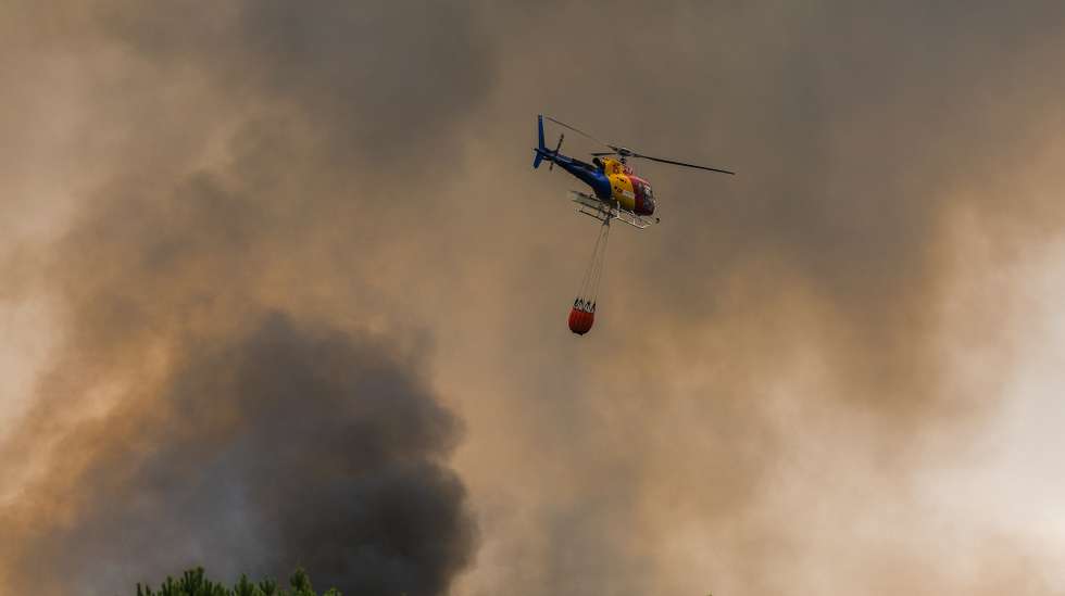 Um helicóptero combate um incêndio em Testeira, Vila Real, 12 de agosto de 2025. Perto de 1.200 operacionais estavam hoje, pelas 15:15, empenhados no combate aos três mais preocupantes incêndios em destaque pela Proteção Civil, que lavram em Vila Real, Tabuaço e Trancoso. PEDRO SARMENTO COSTA/LUSA