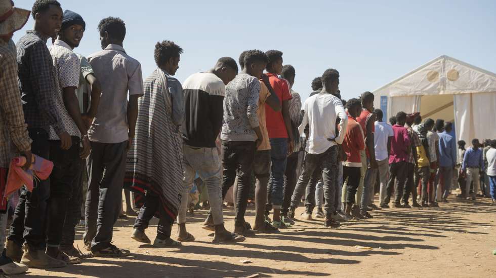 epa08858053 Ethiopian refugees from Tigray region wait in line to receive aid at the Um Rakuba refugee camp, the same camp that hosted Ethiopian refugees during the famine in the 1980s, some 80 kilometres from the Ethiopian-Sudan border in Sudan, 30 November 2020 (issued 02 December 2020). According to World Food Programme on 02 December, about 12,000 Ethiopian refugees from Tigray are accommodated in the Um Rakuba camp as over 40,000 Ethiopian refugees fled to Sudan since the start of fights in the northern Tigray region of Ethiopia. Ethiopia's military intervention   comes after Tigray People's Liberation Front (TPLF) forces allegedly attacked an army base on 03 November 2020 sparking weeks of unrest. According to reports on 02 December 2020, UN reached an agreement with Ethiopian government to provide aid for the Tigray region of Ethiopia.  EPA/ALA KHEIR