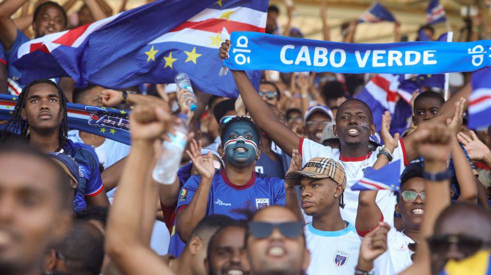 Adeptos da seleção de futebol de Cabo Verde festejam durante o jogo de futebol da última jornada de qualificação para o Mundial2026 contra o Essuatíni , no Estádio Nacional, na Praia, Cabo Verde, 13 de outubro de 2025. Cabo Verde apurou-se hoje pela primeira vez para a fase final de um Mundial de futebol, ao impor-se na receção ao Essuatíni (3-0), na última jornada da qualificação africana, em que foi superior no segundo tempo. ELTON MONTEIRO/LUSA