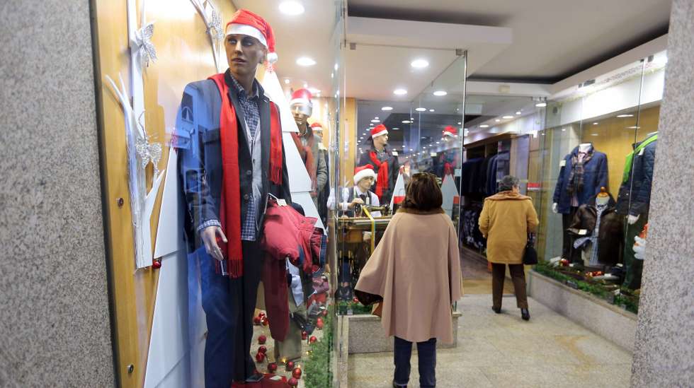 Transeuntes observam as montras na zona histórica de Évora, 12 de dezembro de 2017. As vendas de Natal no comércio tradicional de Évora foram pouco afetadas pela recente abertura de um centro comercial na cidade alentejana, enquanto no distrito o cenário está "ao nível do ano passado". (ACOMPANHA TEXTO DE 15 DE DEZEMBRO DE 2017). NUNO VEIGA/LUSA