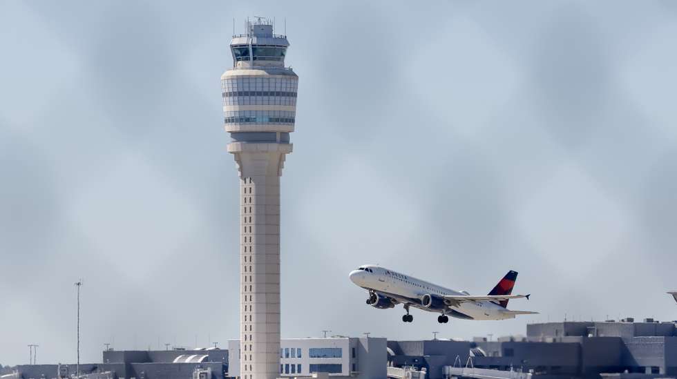 epa12445716 A Delta Air Lines flight passes in front of the Air Traffic Control tower while departing from Hartsfield-Jackson Atlanta International Airport in Atlanta, Georgia, USA, 10 October 2025. The prolonged US federal government shutdown has resulted in delays for air travelers. Employees with the Transportation Security Administration (TSA) and Federal Aviation Administration (FAA) Air Traffic Control are among the 'essential workers' who are working without pay.  EPA/ERIK S. LESSER