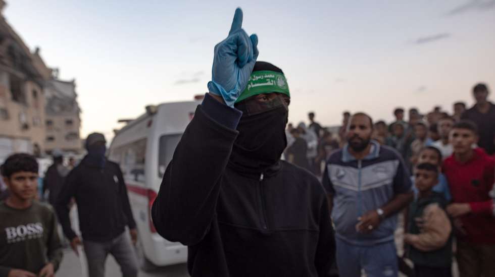 epa12487922 Palestinians watch as members of the Al-Qassam Brigades, the military wing of Hamas, retrieve the body of an Israeli hostage from a tunnel in the Hamad City area of Khan Yunis, southern Gaza, 28 October 2025.  EPA/HAITHAM IMAD