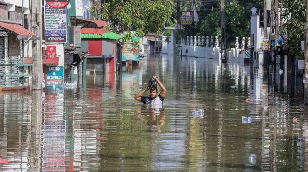 epa12559521 A person wades through a flooded road after heavy rainfall in a suburb of Colombo, Sri Lanka, 30 November 2025. Many parts of the island have been inundated due to heavy rains. According to the Sri Lanka Disaster Management Center, more than 160 people have been killed and about 200 are missing around the country.  EPA/CHAMILA KARUNARATHNE