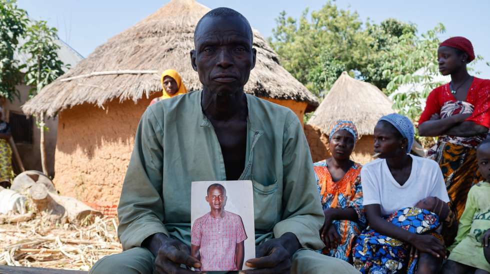 epa12547721 Musa holds a photo of his late son Anthony Musa, in Domogari, Borgu local government, Niger State, Nigeria, 25 November 2025. Anthony Musa passed away after being hospitalised upon leaning of the kidnapping of his two children during the attack at St. Mary's Private Catholic School. Fifty of the 303 schoolchildren abducted from the school have escaped captivity and reunited with their families, according to the Christian Association of Nigeria (CAN).  EPA/AFOLABI SOTUNDE
