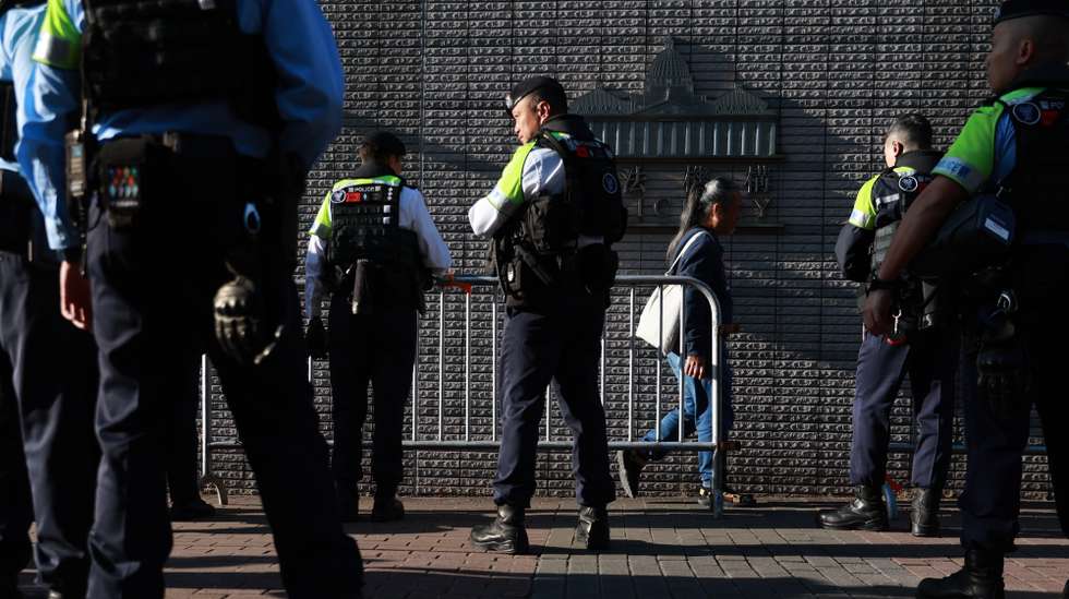 epa12593104 Police officers watch over members of the public entering the West Kowloon Magistrates' Courts Building ahead of a scheduled verdict in the national security trial of pro-democracy media tycoon Jimmy Lai in Hong Kong, China, 15 December 2025. Lai is charged with colluding with foreign forces and publishing seditious materials. He has been denied bail since December 2020 and could face life in prison if convicted. The case has drawn international scrutiny amid ongoing concerns over judicial independence and political freedoms in the city.  EPA/MAY JAMES